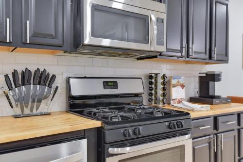 a kitchen with a stove and a microwave at Stylish 2BR Near Union Market & Metro in Washington, D.C.