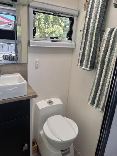 a small bathroom with a toilet and a window at Modern 4 Berth Van close to CBD in Newstead