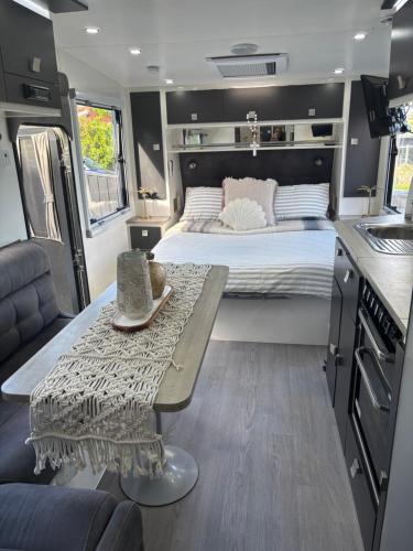a bedroom with a bed and a table in a rv at Modern 4 Berth Van close to CBD in Newstead