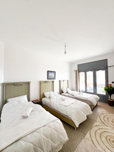 three beds are lined up in a room at Dar Baba Hassan - Ocean View & Ensuite in Taghazout
