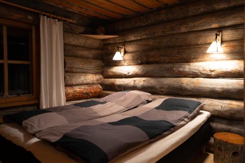 a bedroom with a bed in a wooden wall at Rahkis Lodge Saariselkä in Saariselka