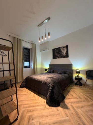 a bedroom with a large bed and a chair at Casa Amore Design - South Sardinia - in San Gavino Monreale
