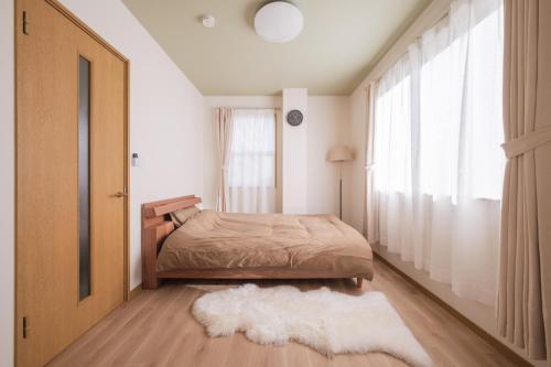a bedroom with a bed and a window and a rug at Genkido-Private House in Takasaki