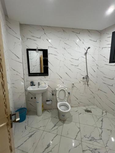 a white bathroom with a toilet and a sink at Florida Waves in El Jadida