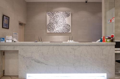 a large marble counter in a bathroom with a picture on the wall at 釜石ベイシティホテル in Kamaishi