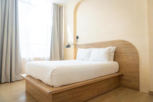 a bed with a wooden headboard in a room at Hotel & hostal Morada in Puebla