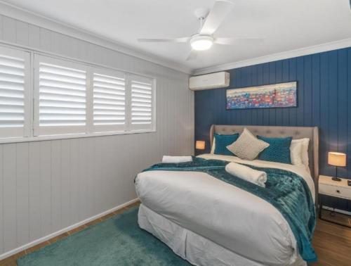 a bedroom with a large bed with blue walls at The Mooloolaba Gallery in Mooloolaba