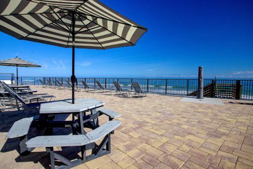a table and chairs with an umbrella on the beach at La Bella Inn - POOL OPEN in Daytona Beach