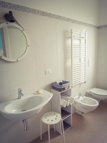 a white bathroom with a sink and a toilet at B&B La Rosa dei Venti in Ginosa Marina