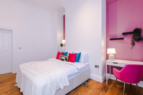 a bedroom with a bed and a pink wall at Parliament St Apt 2 - Central Hull - Sleeps 4 in Hull