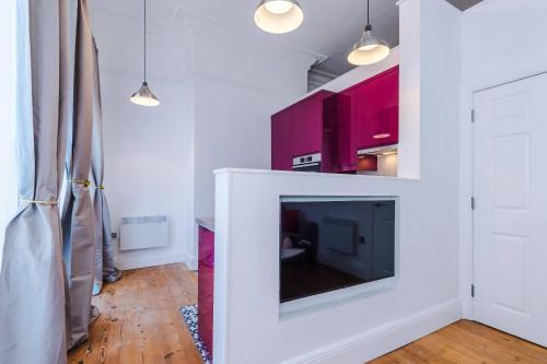 a living room with a fireplace and a tv at Parliament St Apt 2 - Central Hull - Sleeps 4 in Hull