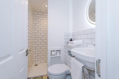 a white bathroom with a toilet and a sink at Parliament St Apt 2 - Central Hull - Sleeps 4 in Hull