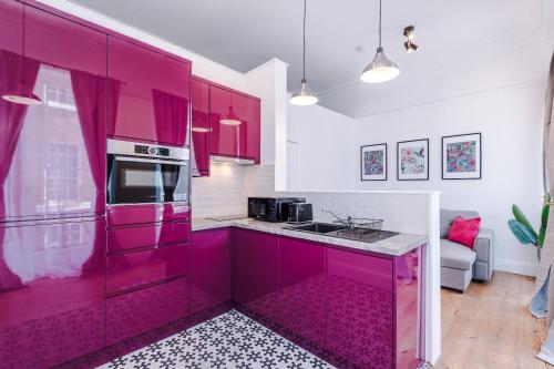 a kitchen with pink cabinets and a stove top oven at Parliament St Apt 2 - Central Hull - Sleeps 4 in Hull