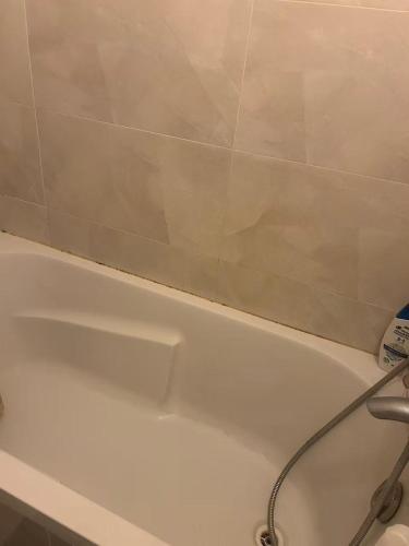 a white bath tub with a shower head at Bagneux cozy in Châtillon