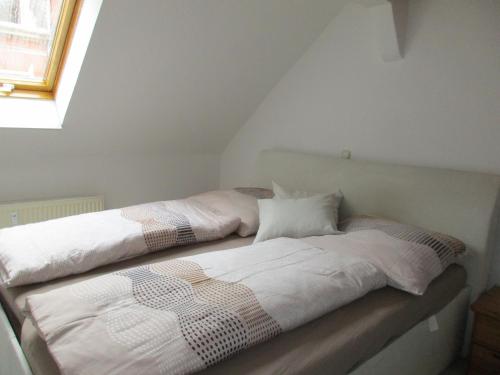 グライツにあるFerienwohnung Kopp Iの屋根裏部屋に白いシーツと枕が備わったベッドが2つ