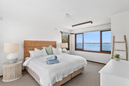 a bedroom with a large bed with a view of the ocean at River Meets Ocean Edge - Absolute Waterfront in Barwon Heads