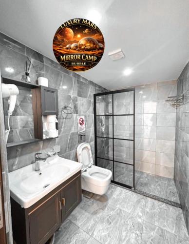 a bathroom with a white toilet and a sink at MARS MIRROR BUBBLE lUXURY CAMP in Wadi Rum