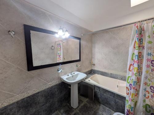 a bathroom with a sink and a bath tub at Apartamento céntrico Campana in Campana