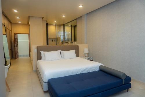 a bedroom with a large bed and a blue bench at Hotel & hostal Morada in Puebla