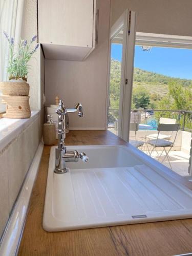 a kitchen sink with a view of a patio at House Sea la vie in Murter