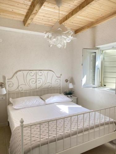 a bedroom with a white bed and a chandelier at House Sea la vie in Murter
