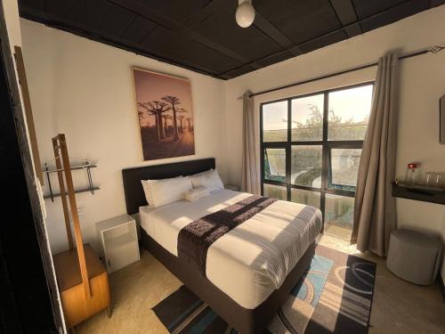 a bedroom with a bed and a large window at Ocean Garden GuestHouse in Ispongo