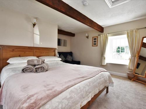 a bedroom with a large bed and a window at 2 Bed in Eyam oc-pk812 in Eyam