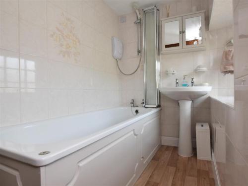 a white bathroom with a tub and a sink at 2 Bed in Eyam oc-pk812 in Eyam