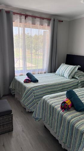 two beds sitting next to each other in a bedroom at Florencia Boutique Cabin in Olmué