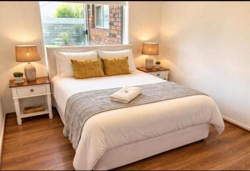 a bedroom with a large bed with two night stands at 47 Murrah - Lux 3 bed home, walk to everything - Pet friendly in Bermagui