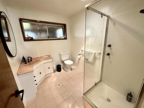 a bathroom with a shower and a toilet and a sink at 47 Murrah - Lux 3 bed home, walk to everything - Pet friendly in Bermagui