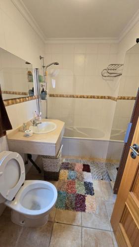 a bathroom with a toilet and a sink and a tub at Jardim do Sol in Jardim do Mar