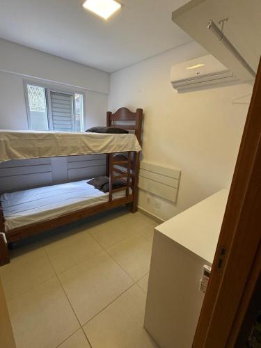 a small bedroom with a bunk bed and a window at Almaré Home in Ubatuba