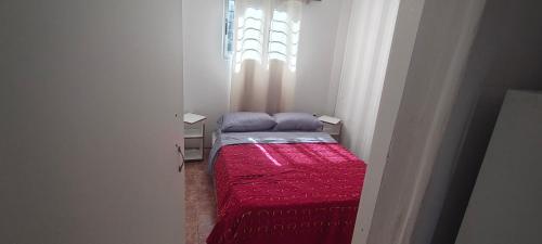 a small bed in a room with a window at Apartamento 2 Guazuvira in Guazuvira