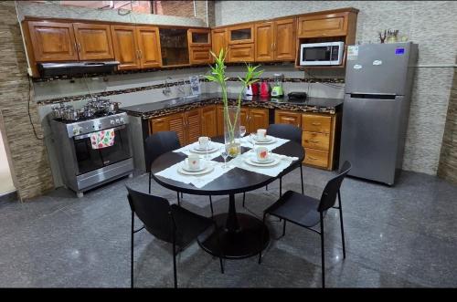 a kitchen with a table with chairs and a refrigerator at Ximena's House in Iquitos