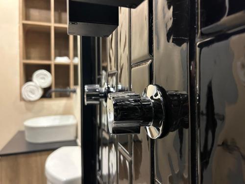 a doorhandle to a bathroom with a toilet at Hotel & hostal Morada in Puebla
