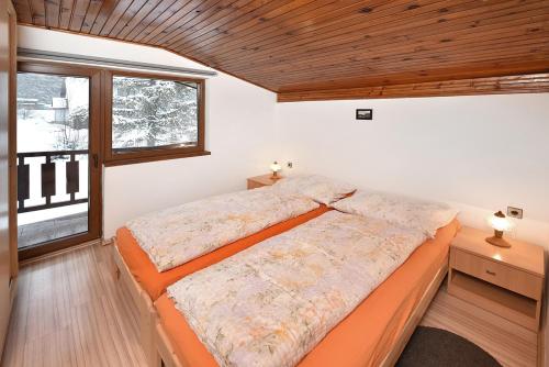 a bedroom with a large bed and a window at Chata Anna Tatranská Štrba in Štrba