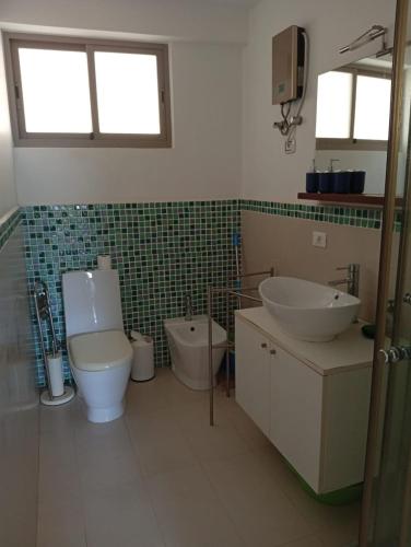 a bathroom with a toilet and a bidet and a sink at Sol Lazareto Mindelo in Prainha