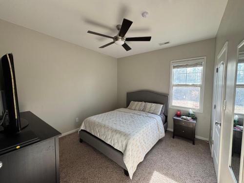 a bedroom with a bed and a ceiling fan at The Bee & Bramble in Raeford