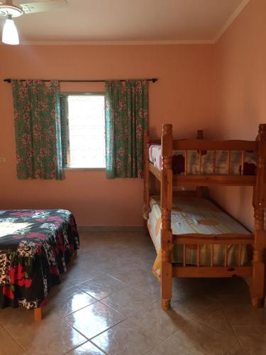 a bedroom with two bunk beds and a window at Sítio primavera socorro-sp in Socorro