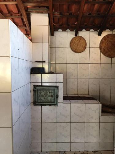 a room with a tile wall with a stove at Sítio primavera socorro-sp in Socorro
