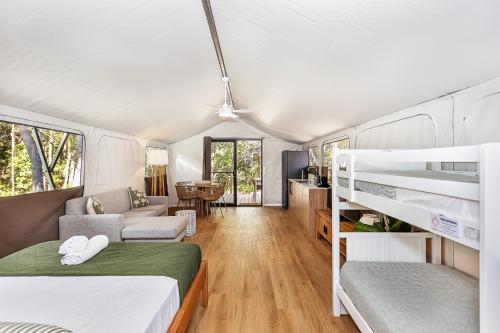 a bedroom with two bunk beds and a living room at Tweed Holiday Parks Pottsville North in Pottsville