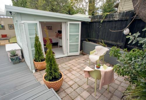 a patio with potted plants and a table and chairs at Finnis Studio in Napier