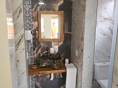a bathroom with a sink and a mirror at Aromas&Brumas Pousada in Brumadinho