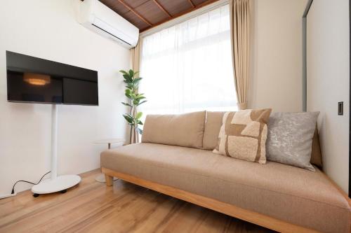a living room with a couch and a window at 久里浜 in Kubiri