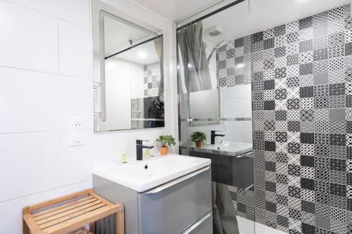 a white bathroom with a sink and a mirror at Instant Pyrénéen in Lourdes