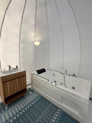a bathroom with a large tub and a sink at Hotel Cielo Stellato in Capitán Pastene