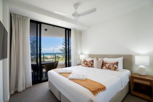 a bedroom with a bed with a view of the ocean at X Kirra Apartments in Gold Coast