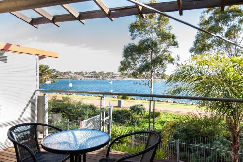 a balcony with a table and chairs and a view of the water at Majestic Oasis Apartments in Port Augusta