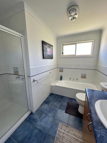 a bathroom with a tub and a toilet and a sink at Famlee Ties in Venus Bay